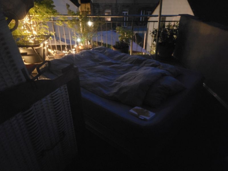 Bett draußen auf einem Balkon im Dunkeln