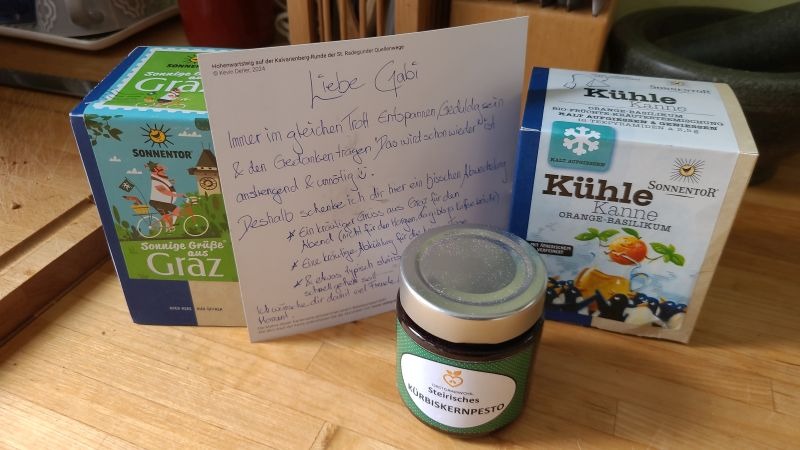 Zwei Packungen Tee, ein Glas Pesto und eine persönliche Karte an Gabi auf einem Küchentisch.