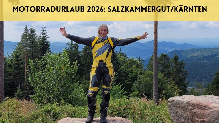 Frau steht in gelbschwarzer Motorradkombi mit ausgebreiteten Armen vor Panorama im Nordschwarzwald. Darüber der Text: Motorradurlaub 2026: Salzkammergut/Kärnten